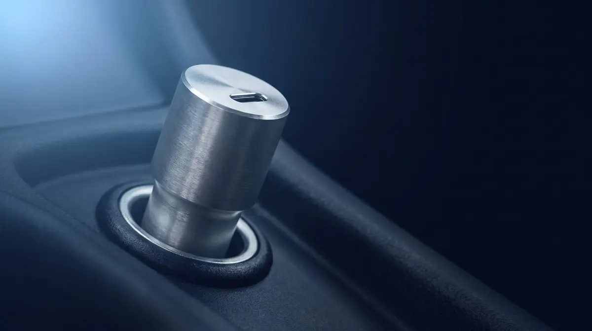Zwei USB-C-Autoladegeräte im Zigarettenanzünder eines Fahrzeugs, Telefon in der Halterung mit Navigation auf dunklem Hintergrund